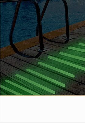 Glow in the dark anti-slip strips on a pool ladder at night